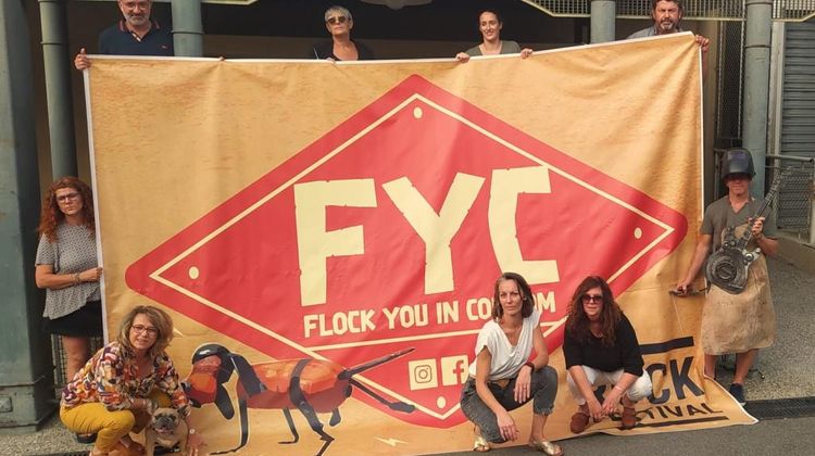 L'équipe du festival pose autour du panneau géant représentant le logo